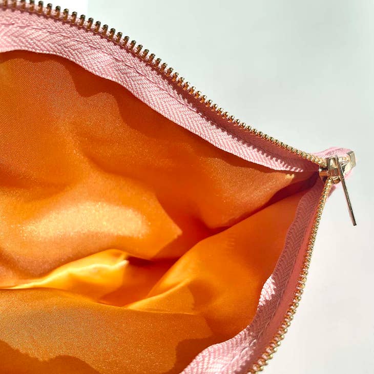 interior of makeup bag with orange satin lining 