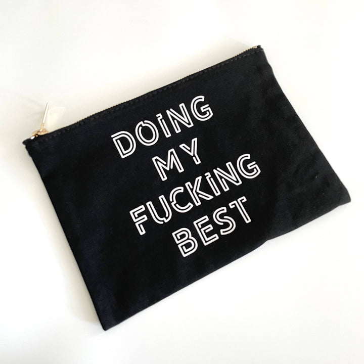 black makeup bag with white block writing that says "Doing My Fucking Best"
